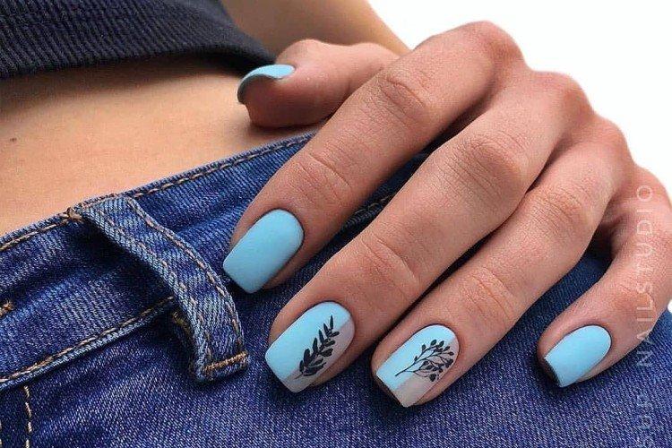 Manucure bleue avec des dessins de brindilles et de feuilles